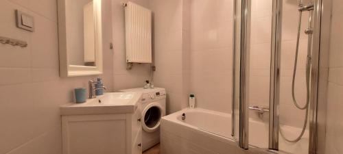 a bathroom with a washing machine and a sink at Pod Mewą Sopot Monte Cassino NEW in Sopot