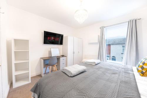 1 dormitorio con cama, escritorio y ventana en *King Bed* Comfy City House, en Barrow-in-Furness