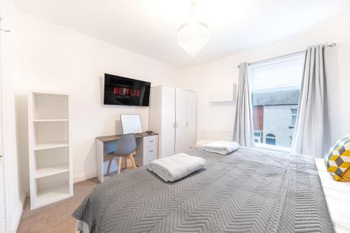 a bedroom with a bed and a desk and a window at *King Bed* Comfy City House in Barrow in Furness