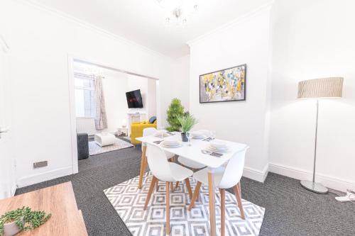 un soggiorno con tavolo e sedie bianchi di *King Bed* Comfy City House a Barrow in Furness