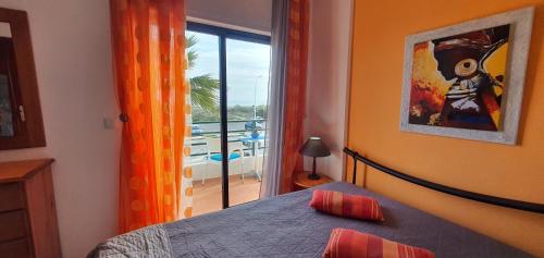 a bedroom with a bed and a window with a view at Monte Gordo T2 Frente Mar in Monte Gordo