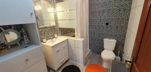 a bathroom with a toilet and a sink and a mirror at Monte Gordo T2 Frente Mar in Monte Gordo
