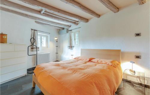 um quarto com uma cama grande e um cobertor laranja em La Guardiola em San Nazzaro