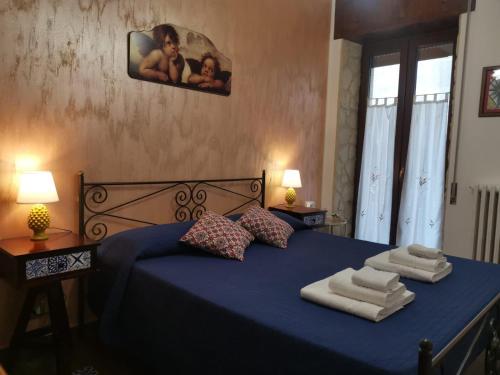 a bedroom with a blue bed with towels on it at Del Centro in Enna