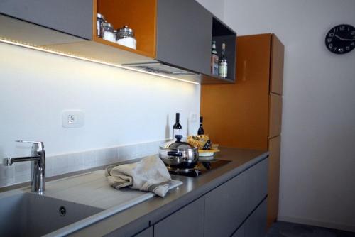 uma cozinha com um lavatório e um fogão forno superior em Due Colonne em Menaggio