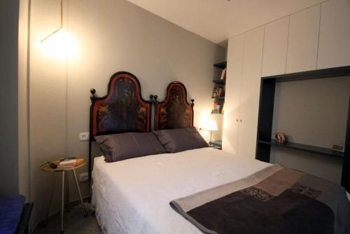 a bedroom with a large bed with a wooden headboard at Due Colonne in Menaggio