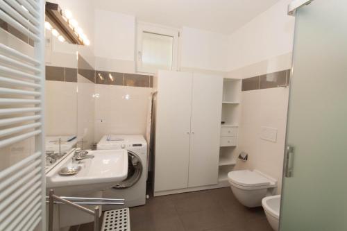 bagno bianco con lavandino e servizi igienici di IsaBellaVista a Tremezzo