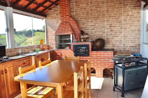 a kitchen with a wooden table and a brick wall at Casa Fiorelli in Cunha