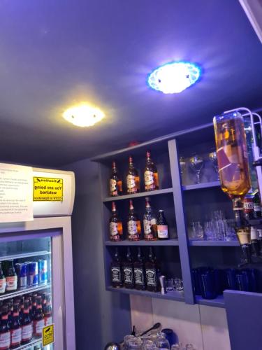 a bar with bottles of alcohol on a shelf at Family Home in Liverpool