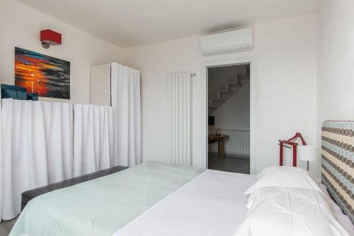 une chambre blanche avec un lit et une fenêtre dans l'établissement Stairway to Heaven - Pianello del Lario by LoveComo, à Pianello Del Lario