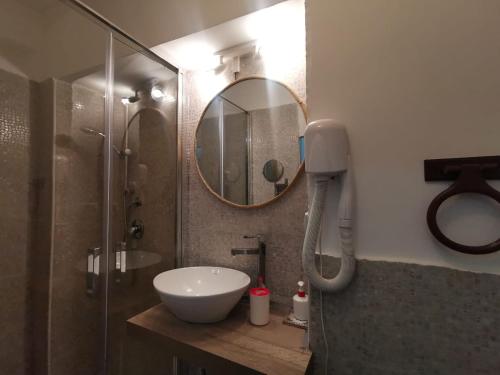 a bathroom with a sink and a shower with a mirror at Del Centro in Enna
