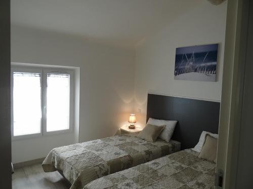 Cette chambre blanche dispose de 2 lits et de 2 fenêtres. dans l'établissement Day's Inn Cannes, à Cannes