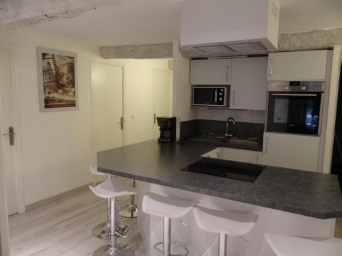 - une cuisine avec un comptoir en granit et des tabourets dans l'établissement Day's Inn Cannes, à Cannes