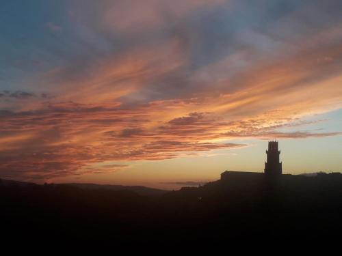 a silhouette of a building with a sunset in the background at casa il Girasole Pitigliano in Pitigliano