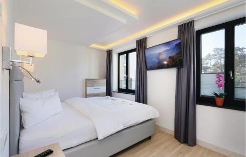 a bedroom with a large white bed with windows at Pearl in Binz