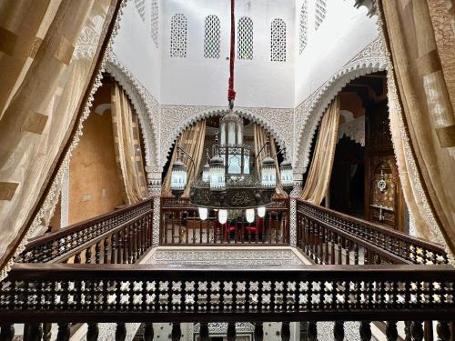 a staircase in a building with a chandelier at Riad Mogador in Meknès
