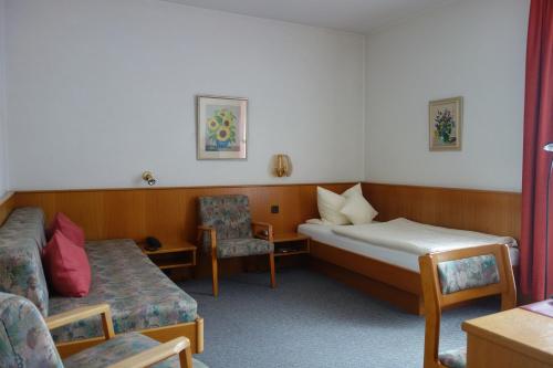 Zimmer mit einem Bett, einem Sofa und einem Stuhl in der Unterkunft Hotel Lex in Hagen