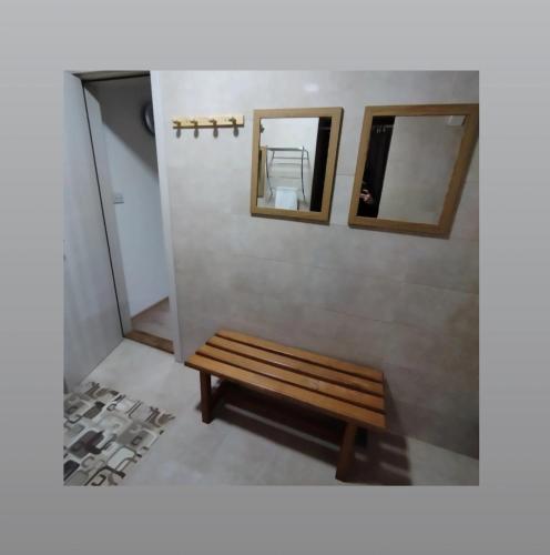 a wooden bench in a room with two mirrors at Apartmani S - DSN in Kraljevo