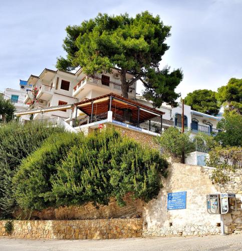 a house on a hill with a tree on top at Pension Dimitris in Votsi