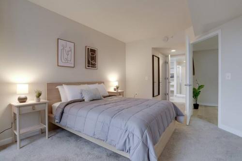 a white bedroom with a large bed and two lamps at Spacious 2 BR Apartment At Pentagon City in Arlington