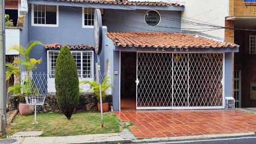 una casa azul con una puerta delante de ella en Hotel Loft Dorado Bucaramanga, en Floridablanca