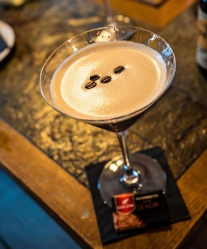 a drink in a martini glass on a table at Atmosphere Hotel in Les Deux Alpes