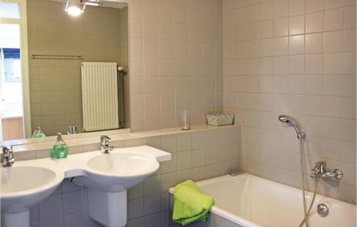 uma casa de banho com um lavatório, uma banheira e um espelho. em 3 Bedroom Gorgeous Home In Workum em Workum