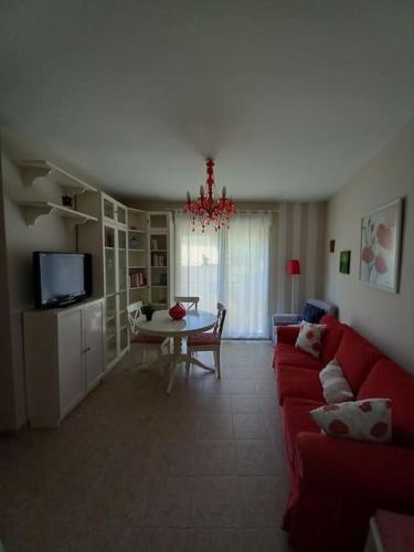 a living room with a red couch and a table at Apartamento tranquilo cerca de zonas verdes in Cieza