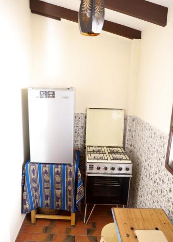 a kitchen with a refrigerator and a stove and a table at Olala house in Sucre