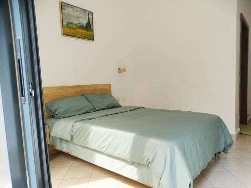 1 dormitorio con 1 cama en una habitación blanca en Greedy Five Kigali, en Kigali