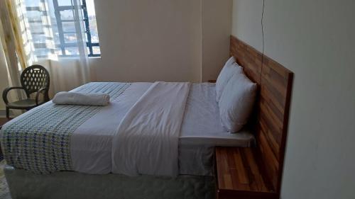a bedroom with a large bed with a wooden headboard at Marvel Studio Kitengela Yukos in Kitengela 