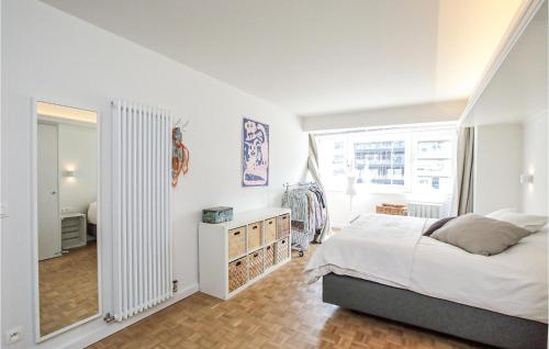 Habitación blanca con cama y espejo en The Coastal Residence, en Ostende