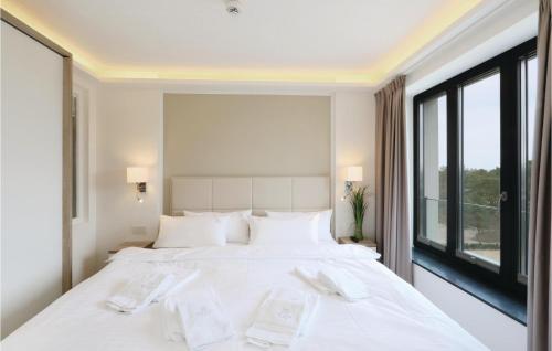 um quarto branco com uma cama grande e uma janela em Sky Suite Eden em Binz