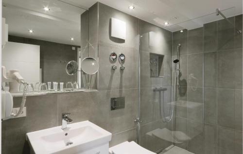 uma casa de banho com um chuveiro e um lavatório. em Sky Suite Eden em Binz