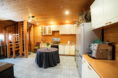 a kitchen with a table in the middle of it at Viesu nams SAKNĪTES in Dzērbene