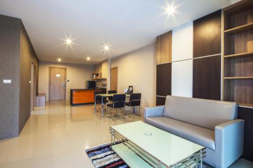 a living room with a couch and a table at Golden City Rayong Hotel in Rayong