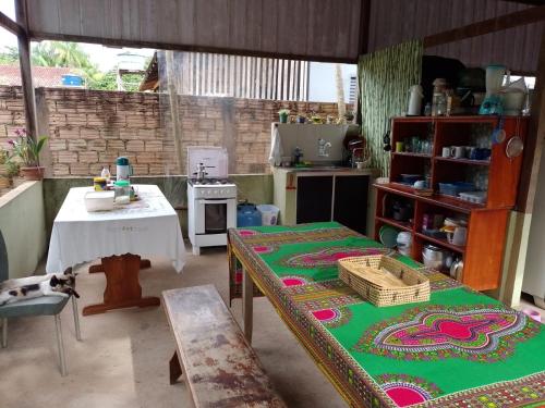 Una habitación con una mesa y una cocina con una sidra de mesa en Caju Hostel en Alter do Chao
