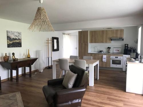 kuchnia i salon ze stołem i kanapą w obiekcie Gîte Au Petit Bonheur w mieście Saint-Savinien