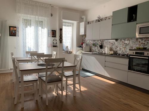a kitchen with white cabinets and a table and chairs at Casa GEOROSS in Verona