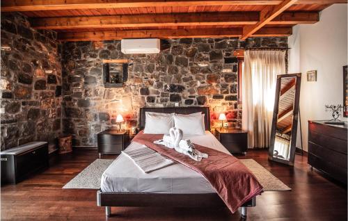 a bedroom with a bed and a stone wall at Amazing Home In Milatos, Lasithi With 4 Bedrooms, Private Swimming Pool And Outdoor Swimming Pool in Milatos