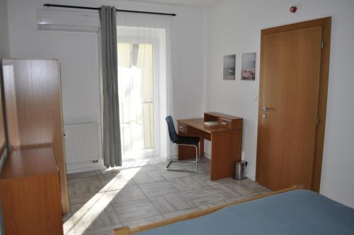 Schlafzimmer mit einem Bett, einem Schreibtisch und einem Fenster in der Unterkunft Apartment Adam & Eva in Piešťany