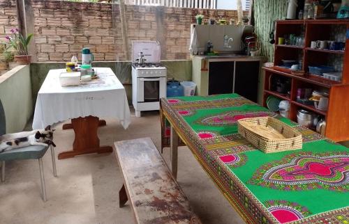 a kitchen with a table and a table with a cat laying on it at Caju Hostel in Alter do Chao