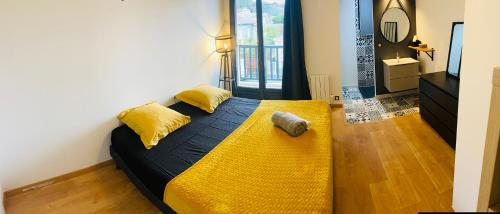 Un dormitorio con una cama con almohadas amarillas. en Millésime, en Cenon