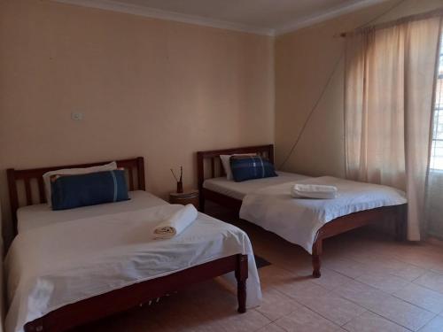 a room with two beds in a room at Razy's in Kakamega