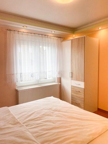 ein Schlafzimmer mit einem weißen Bett und einem Fenster in der Unterkunft Extrem ruhiges Apartment- Leipzig Ost (A14) in Leipzig