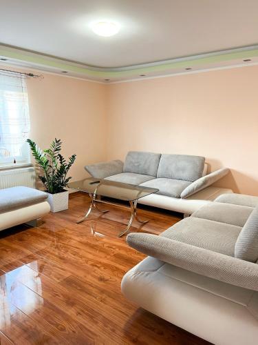 ein Wohnzimmer mit zwei weißen Sofas in einem Zimmer in der Unterkunft Extrem ruhiges Apartment- Leipzig Ost (A14) in Leipzig