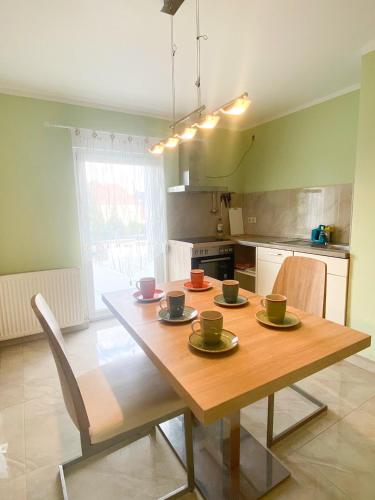 eine Küche mit einem Holztisch mit Tassen und Tellern darauf in der Unterkunft Extrem ruhiges Apartment- Leipzig Ost (A14) in Leipzig