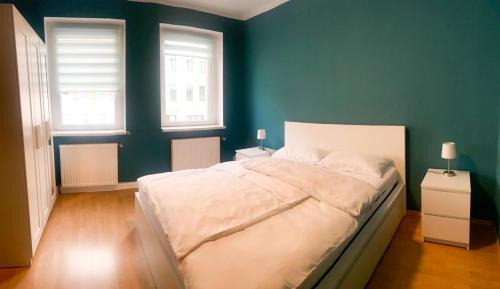 1 dormitorio con 1 cama blanca grande y paredes verdes en 263 Zentrum Nord Apartment Messe,Hbf,A14, en Leipzig