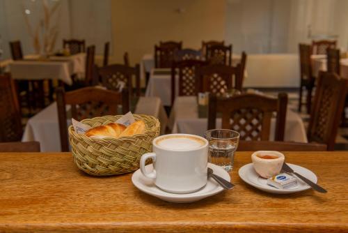 una taza de café y una cesta de pan en una mesa en Hotel Salvador Catamarca en San Fernando del Valle de Catamarca