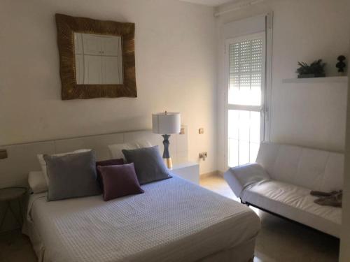 un soggiorno con letto e divano di Apartamento en primera línea de playa a Marbella